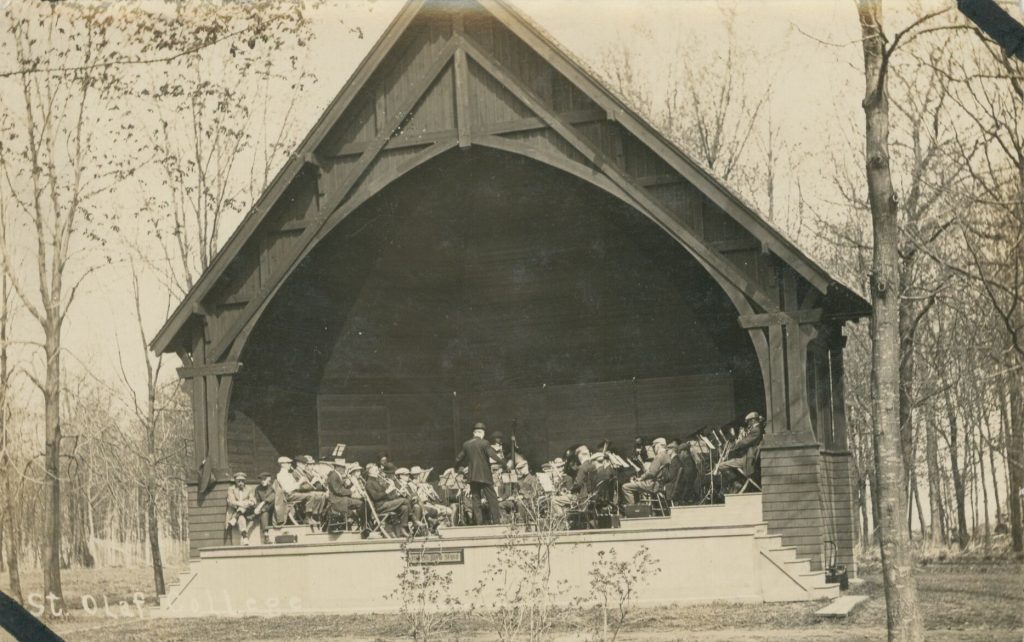 A band performs inside a large wooden bandstand