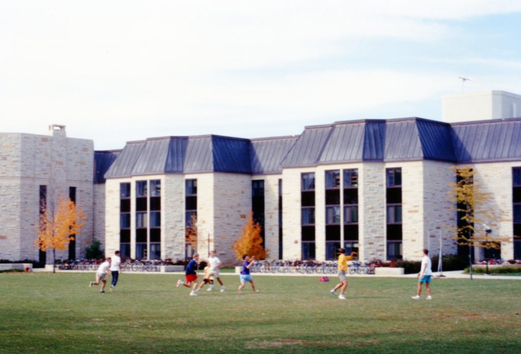 Students playing frisbee in front of Ytterboe Hall