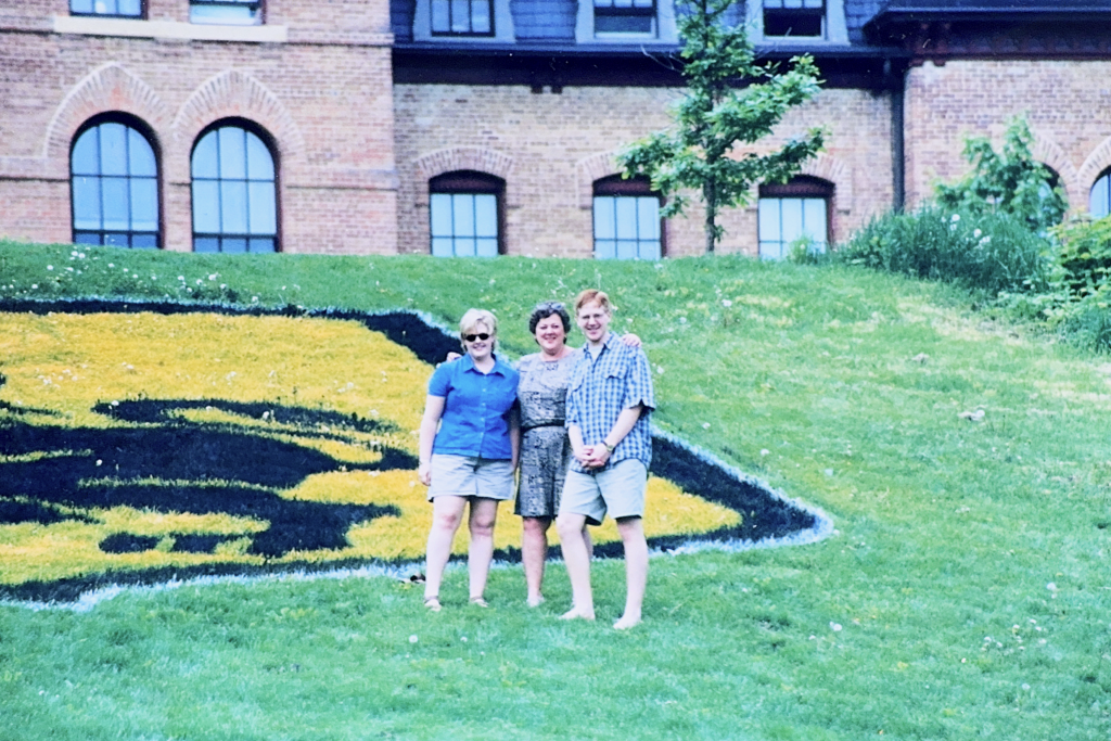 Carey Jacobsen '96, Cheryl Rose Jacobsen '69, and Brook Jacobsen '99 on Old Main Hill, which was decorated with the St. Olaf crest in celebration of the 1999 Commencement Weekend.